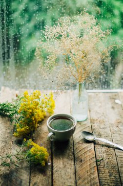 Romantik arka plan ile fincan çay, çiçekler ve açık kitap üzerine 