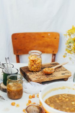 Ahududu reçeli. El sıkışması, rustik bir beyaz masaya yapma