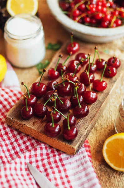 Cerezas rojas frescas sobre una mesa rústica de madera. Cerezas maduras i o — Foto de Stock