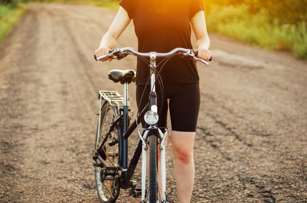 Detalhe de uma bicicleta. Uma mulher a andar de bicicleta. Bicicleta na estrada — Fotografia de Stock