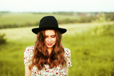 Young woman stay is burned field. Woman stands facing the camera