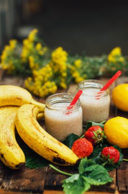 Meyve Smoothies. muz smoothies süt ile. Ahşap bir masa üzerinde Muz Smoothie. Sağlıklı Kahvaltı: muz smoothie yulaf ezmesi ile. Muz smoothie cam ahşap zemin üzerine taze meyve ile