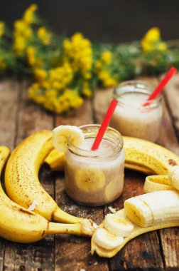 Meyve Smoothies. muz smoothies süt ile. Ahşap bir masa üzerinde Muz Smoothie. Sağlıklı Kahvaltı: muz smoothie yulaf ezmesi ile. Muz smoothie cam ahşap zemin üzerine taze meyve ile