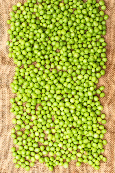 Frozen peas  on a table. Pea pods on green background — Stock Photo, Image