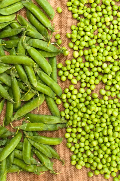 Frozen peas  on a table. Pea pods on green background — Stock Photo, Image