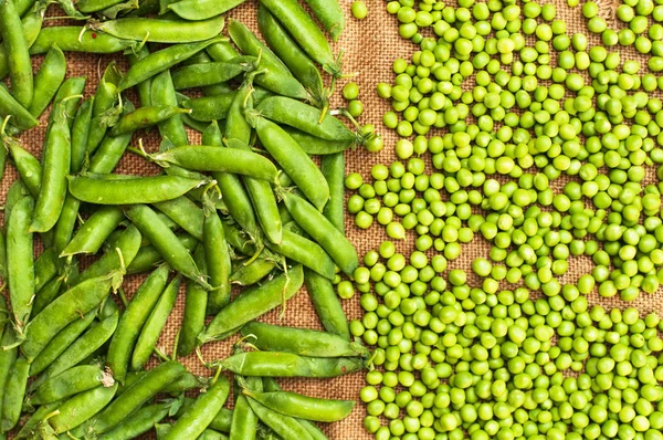Frozen peas  on a table. Pea pods on green background — Stock Photo, Image