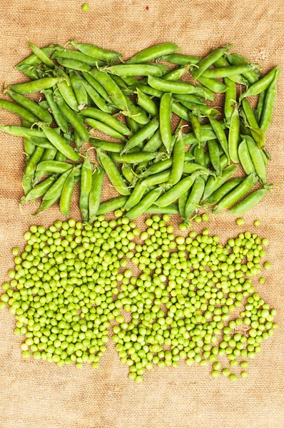 Frozen peas  on a table. Pea pods on green background — Stock Photo, Image