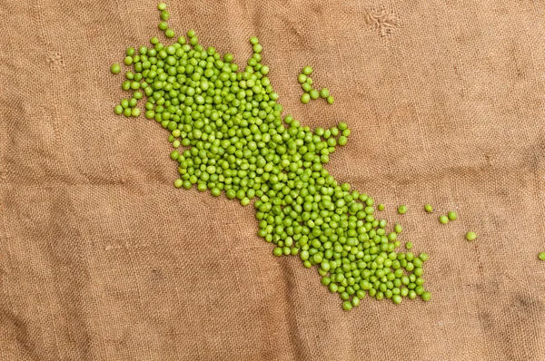 Frozen peas  on a table. Pea pods on green background — Stock Photo, Image