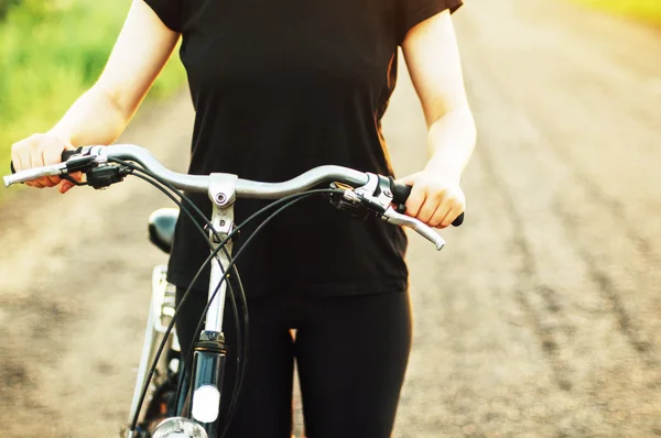 Detail of a bicycle. Woman riding her bicycle. Bicycle  on road — Stock Photo, Image