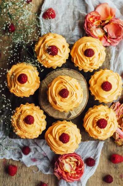 Cupcakes na mesa de madeira. Bolos decorados caseiros na aba — Fotografia de Stock