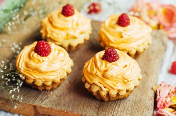 Cupcakes na mesa de madeira. Bolos decorados caseiros na aba — Fotografia de Stock