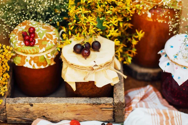 Fosas de fresa caseras. postre hecho de mosto y harina colocada dentro de pequeños frascos. Mermelada de frambuesa casera lista para el almacenamiento. tarro lleno de mermelada de albaricoque casero — Foto de Stock