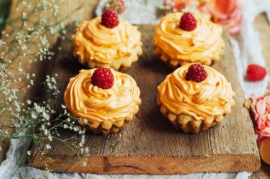  cupcakes ahşap masa üzerinde. Sekmesinde dekore edilmiş ev yapımı kek