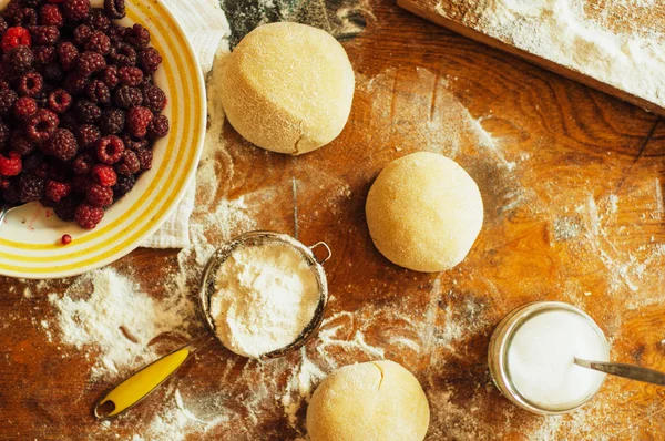 Ev yapımı ahududu kek pişirme. Kadın bir pasta hamuru haddeleme