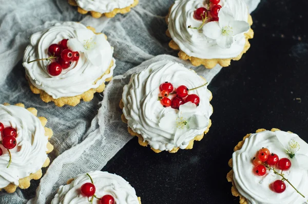 Schöne Schokoladen-Cupcakes mit weißer Eiweißcreme und Kirsche — Stockfoto