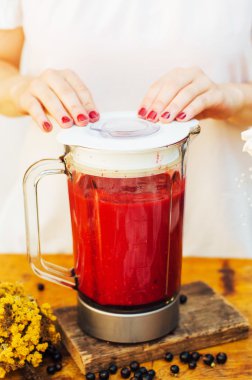 Ahududu, Ahududu, Ahududu, kuş üzümü ile meyve ve berry smoothies. Limon ve su ile çilek coctail. Kiraz ve çilekli smoothie hazırlıyorum. Kadın elleri.