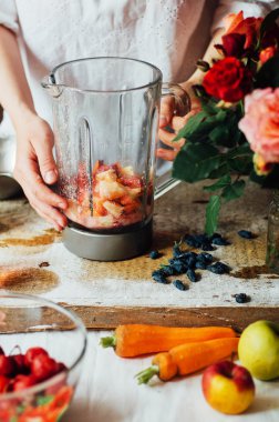 El ahşap tabloda çilek smoothies yapar. Taze strawbe