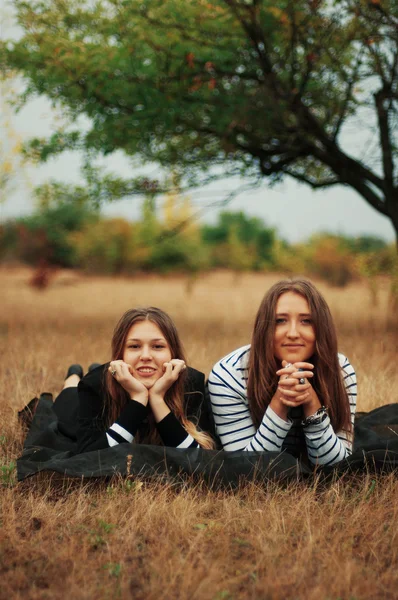 Twee jonge vriendinnen poseren. Twee gelukkige vrienden outdoorstwo youn — Stockfoto