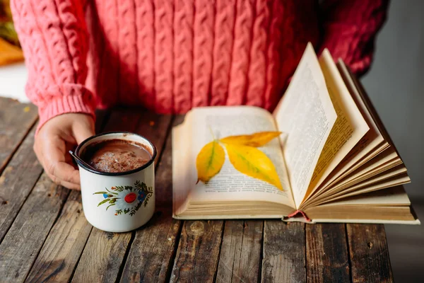 Mulher segurando xícara de chocolate quente. Chocolate quente em tabl de madeira — Fotografia de Stock