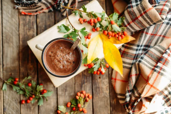 Mulher segurando xícara de chocolate quente. Chocolate quente em tabl de madeira — Fotografia de Stock