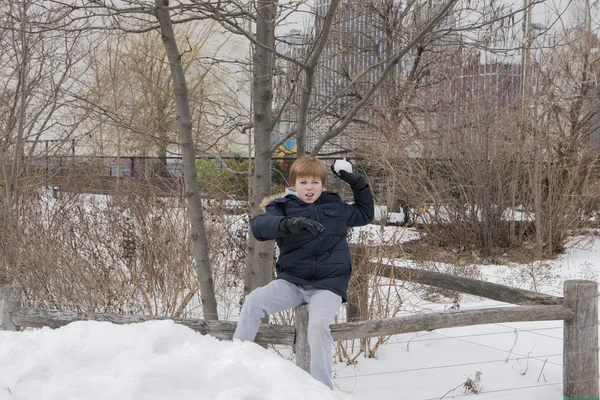Genç çocuk bir kartopu atarak