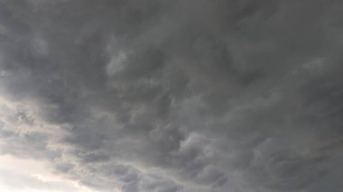 Şiddetli, karanlık fırtına bulutları tüm kareyi doldurup karamsar, atmosferik bir manzara yaratıyor. Koyu gri, kömür buharı katmanları gökyüzünde dönerek güneşi tamamen karartıyor. Bu doğal doku yoğun havayı, yaklaşan yağmuru ve güçlü sinüsü temsil eder.