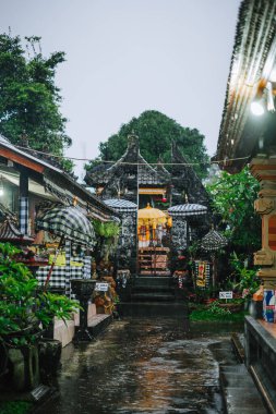 Yağmurlu bir günde, Endonezya 'nın Penglipuran Köyü' nde geleneksel Hint tapınağı mimarisi ve tören şemsiyeleri.