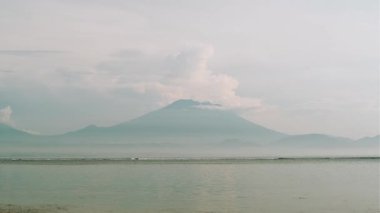 Sanur Sahili, Bali, Endonezya 'da Agung Dağı ile deniz dalgaları seyahat ve tropikal hedef temaları için sakin bir çekim