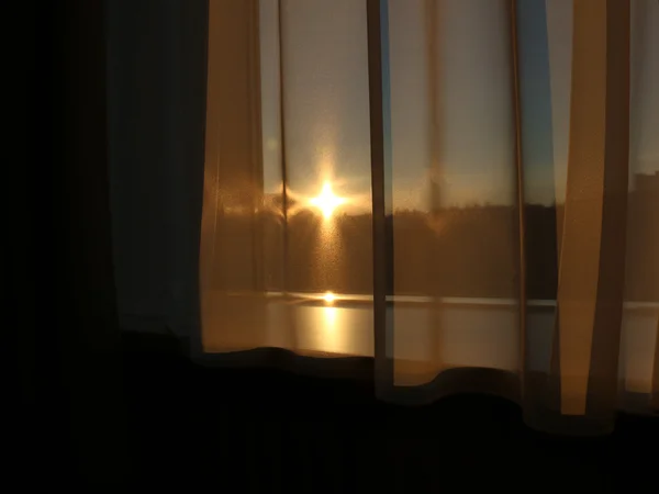 Puesta de sol a través de cortinas — Foto de Stock