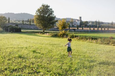Gün batımında sahada koşan küçük bir çocuğun geniş açılı görüntüsü