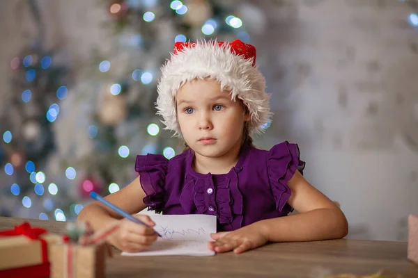 Söt Liten Flicka Skriver Ett Nyårsbrev Till Jultomten Barnet Sitter — Stockfoto