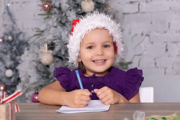 Симпатичная Маленькая Девочка Пишет Новогоднее Письмо Санта Клаусу Ребенок Сидит — стоковое фото