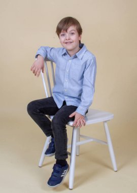 Sarı saçlı şirin bir çocuğun portresi, gülümseyen bir çocuk, mutlu bir çocukluk, model görünümü.