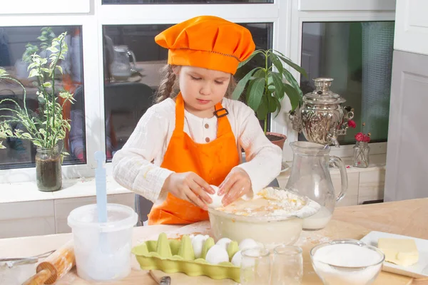 Ein Kleines Süßes Mädchen Orangefarbenen Kochkostüm Bricht Ein Rohes Und — Stockfoto