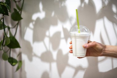 Elleri plastik bardakta içki tutan kadın.