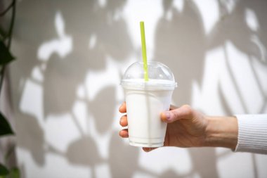 Elleri plastik bardakta içki tutan kadın.