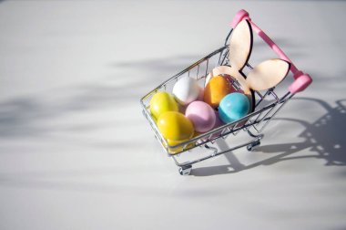 Paskalya yumurtalı süpermarket arabası, Paskalya kompozisyonu, şenlikli parlak arka plan.