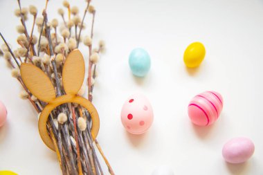 Beyaz arka planda söğüt dalları ve Paskalya yumurtaları, Mutlu Paskalyalar, narin şenlik arka planı, metin için boş alan.
