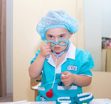 Down sendromlu çocuk, doktor kostümü giymiş genetik engelli bir çocuğun portresi, özel çocuklar, genetik anormallikler..