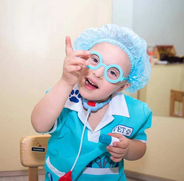 ダウン症候群の少年 医師の衣装で遺伝的に障害のある子供の肖像画 特別な子供 遺伝的異常 — ストック写真