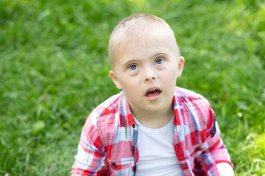 Down sendromlu bir çocuğun portresi, engelli bir çocuk, genetik kromozom hastalığı olan bir çocuk..