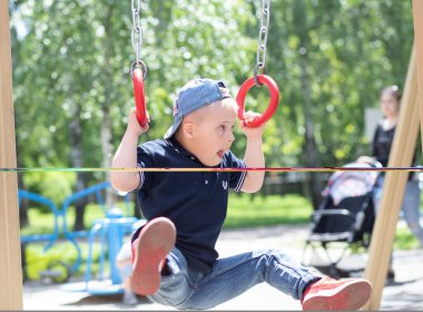 Down sendromlu bir çocuk oyun alanında oynuyor. Engelli bir çocuk, fazladan kromozomu olan bir çocuk..