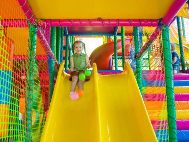 Oyun sahasında arka planda sevimli kız oynuyor.