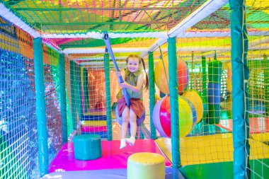 Oyun sahasında arka planda sevimli kız oynuyor.