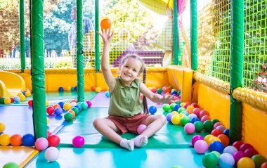 Oyun sahasında arka planda sevimli kız oynuyor.