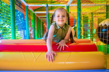 Oyun sahasında arka planda sevimli kız oynuyor.