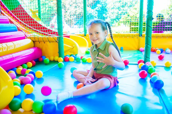 cute girl plays in the play area on background