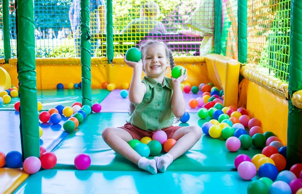 cute girl plays in the play area on background