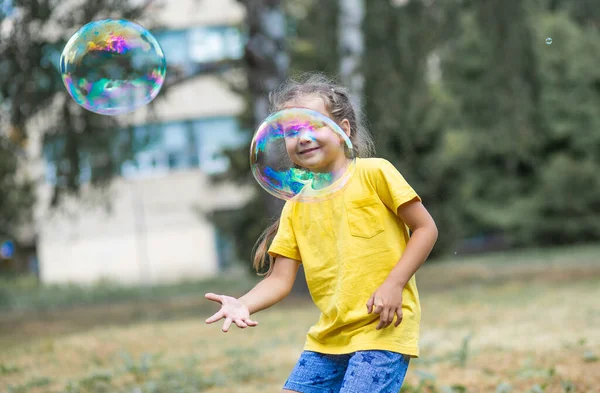 Happy Girl Catches Big Soap Bubbles Child Plays Street Light — 图库照片