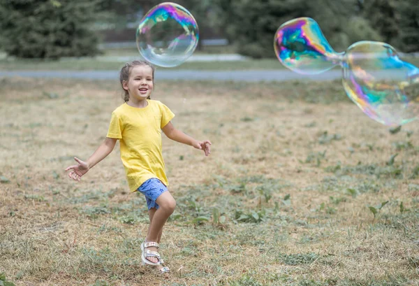 Happy Girl Catches Big Soap Bubbles Child Plays Street Light — 图库照片